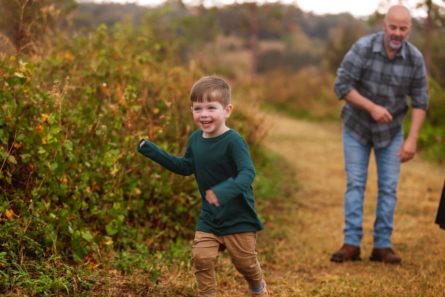 A cheerful scene along an autumn berry bush path on a farm with two people walking and picking fruit.