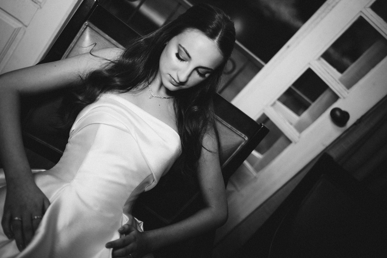 A dramatic black and white portrait of a woman in a white gown.