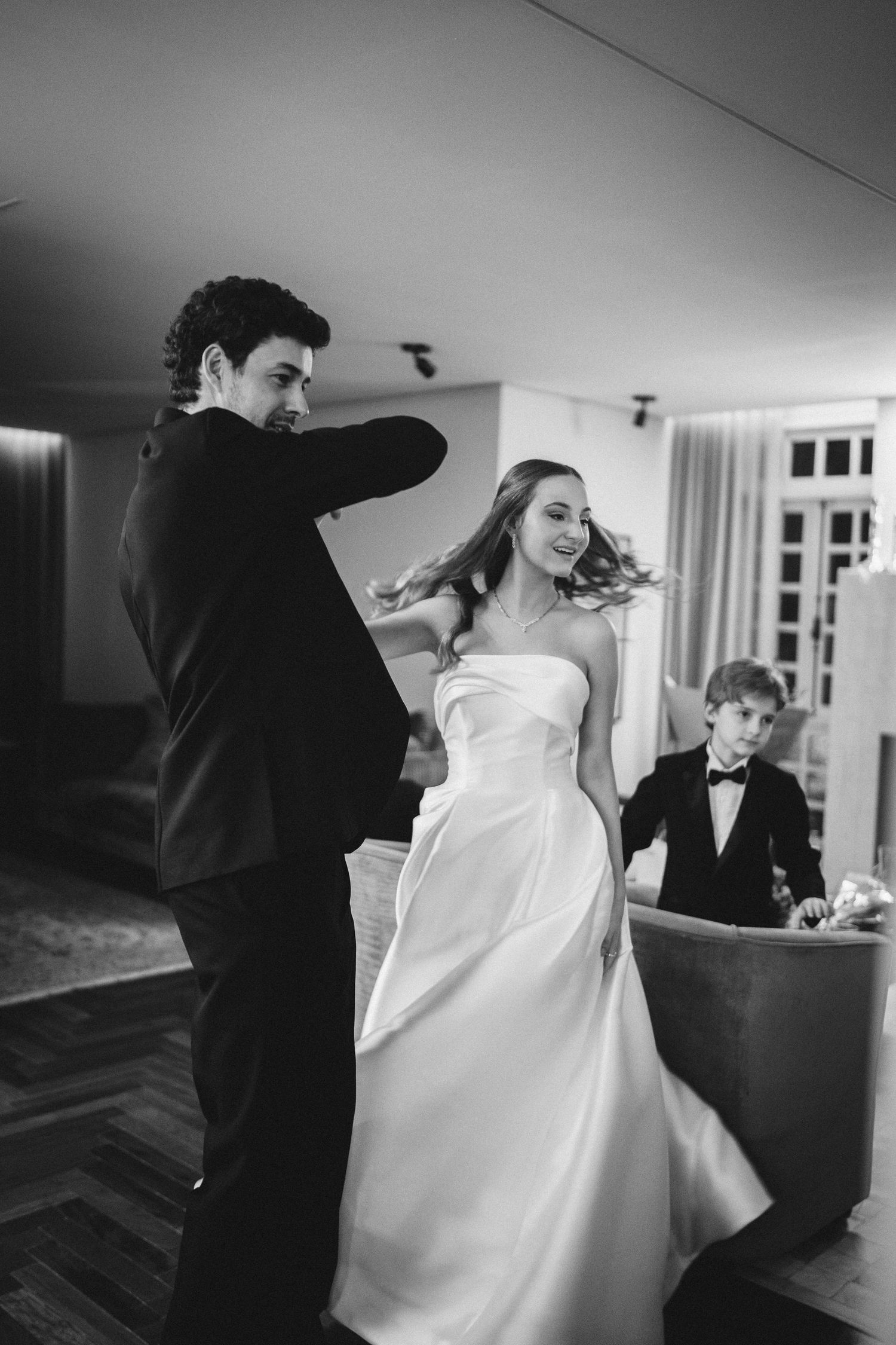 Elegant black and white sequence showing wedding dress preparation moments.