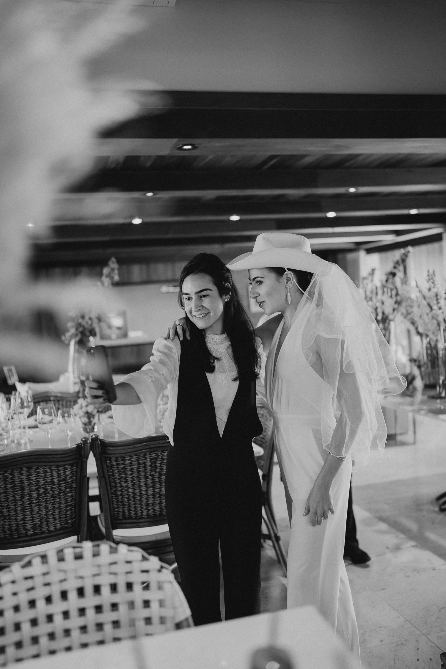 Black and white photo of two people sharing drinks in an indoor venue.