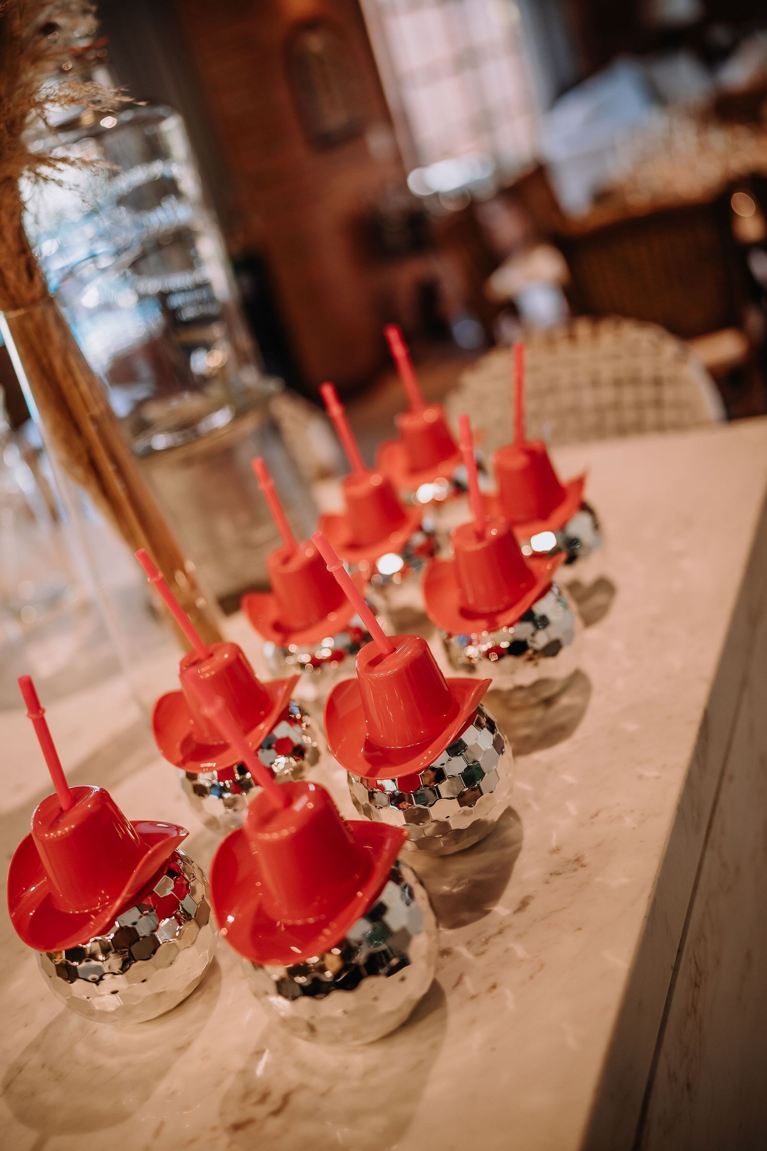 Red and white decorated cake pops arranged in rows on an elegant table setting.