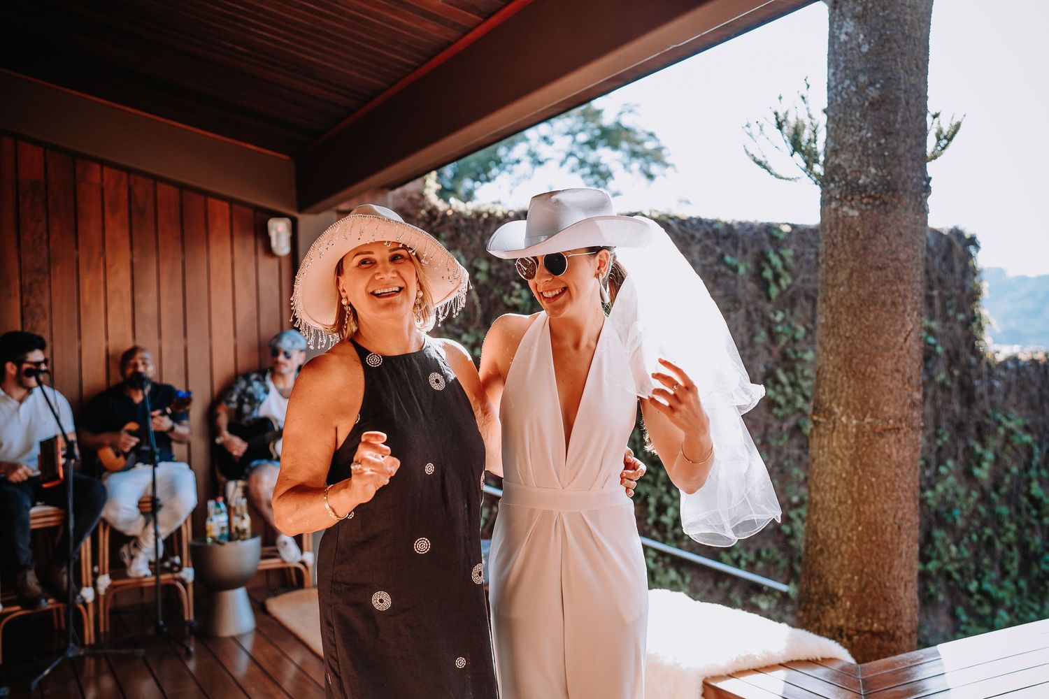 People gathered for celebration in rustic venue with wooden beams and stone pillars.