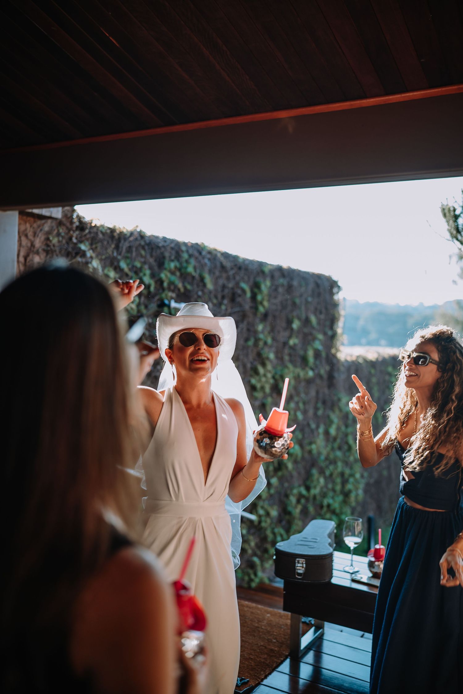 Party guests enjoying drinks and conversation on an outdoor patio with scenic mountain views.