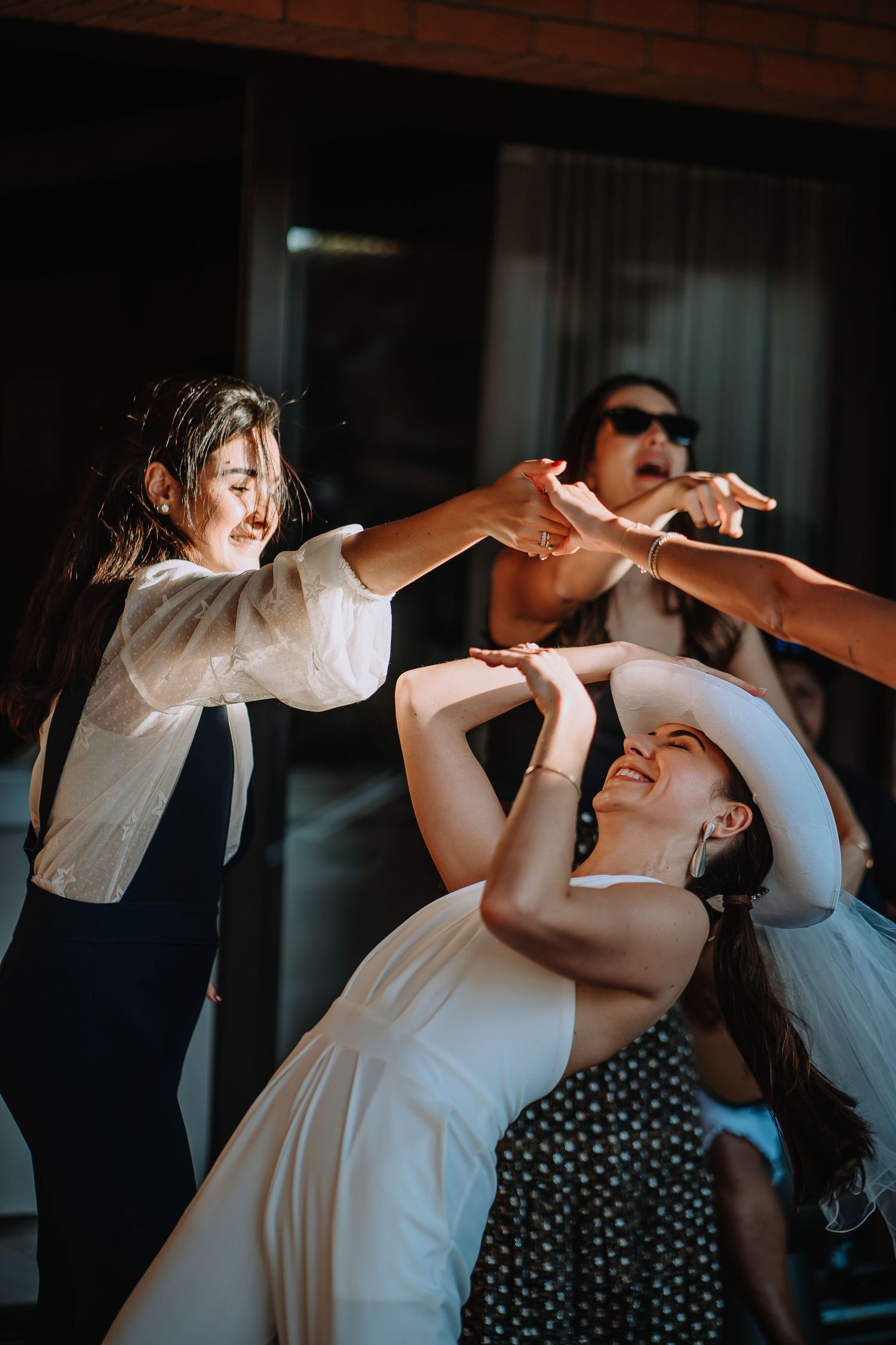 Party guests dancing energetically during celebration with dramatic lighting.