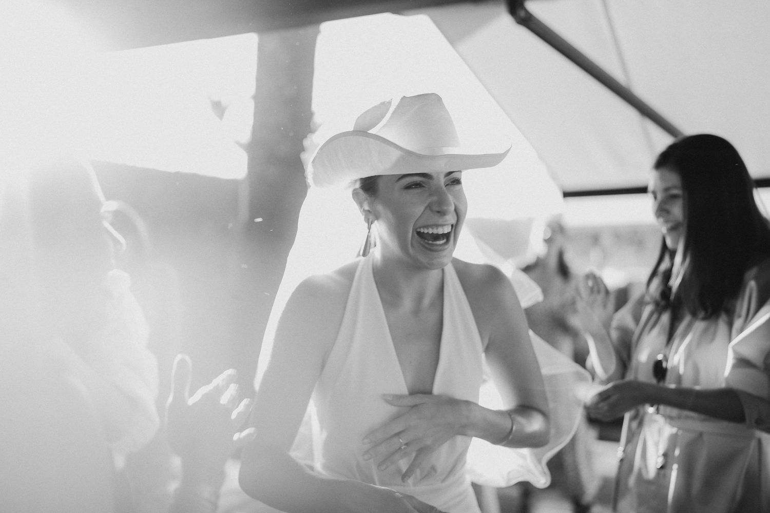 Monochrome image of people dancing and smiling at a lively party.