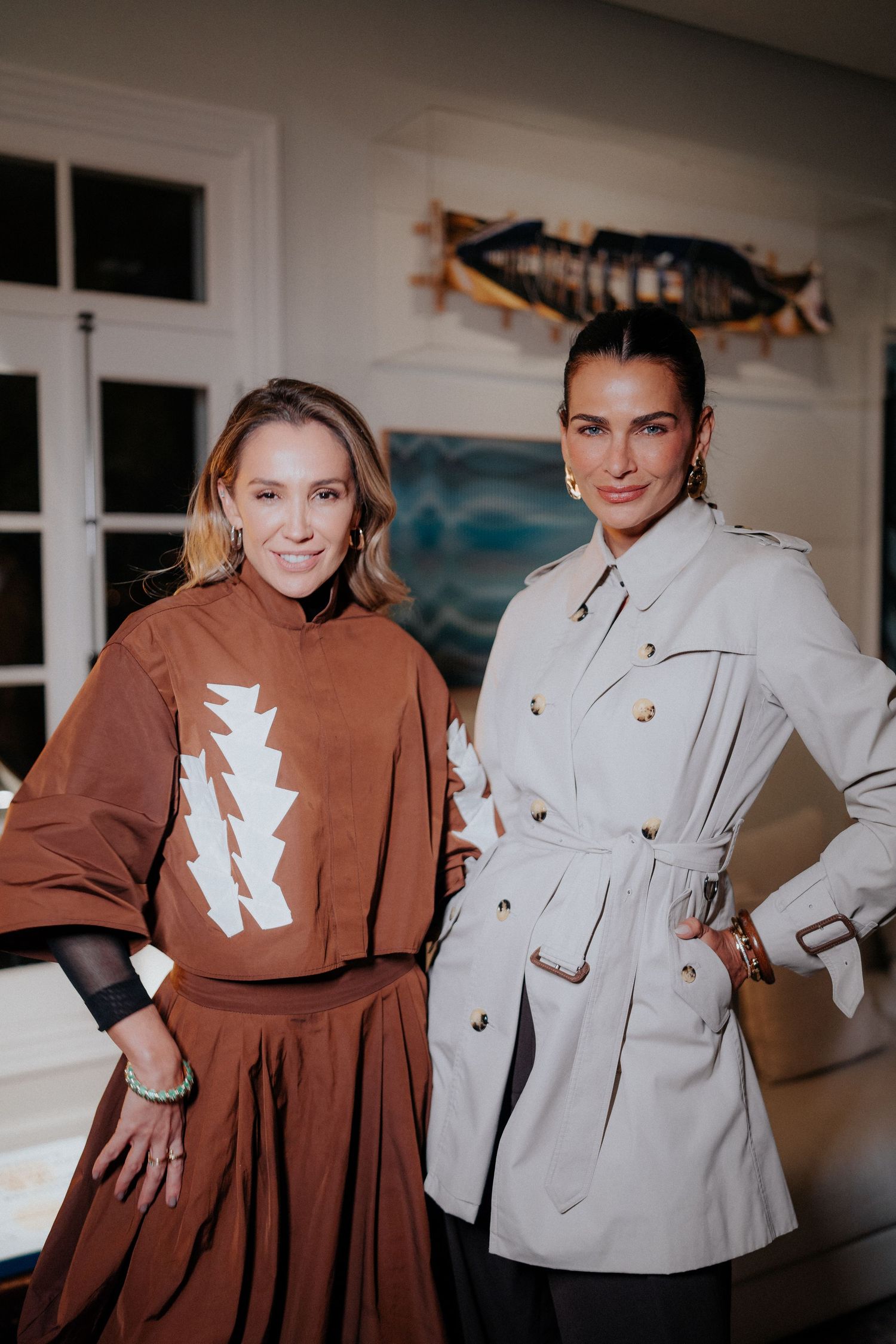 Two people in contrasting outfits, one wearing white coat and other in brown dress.