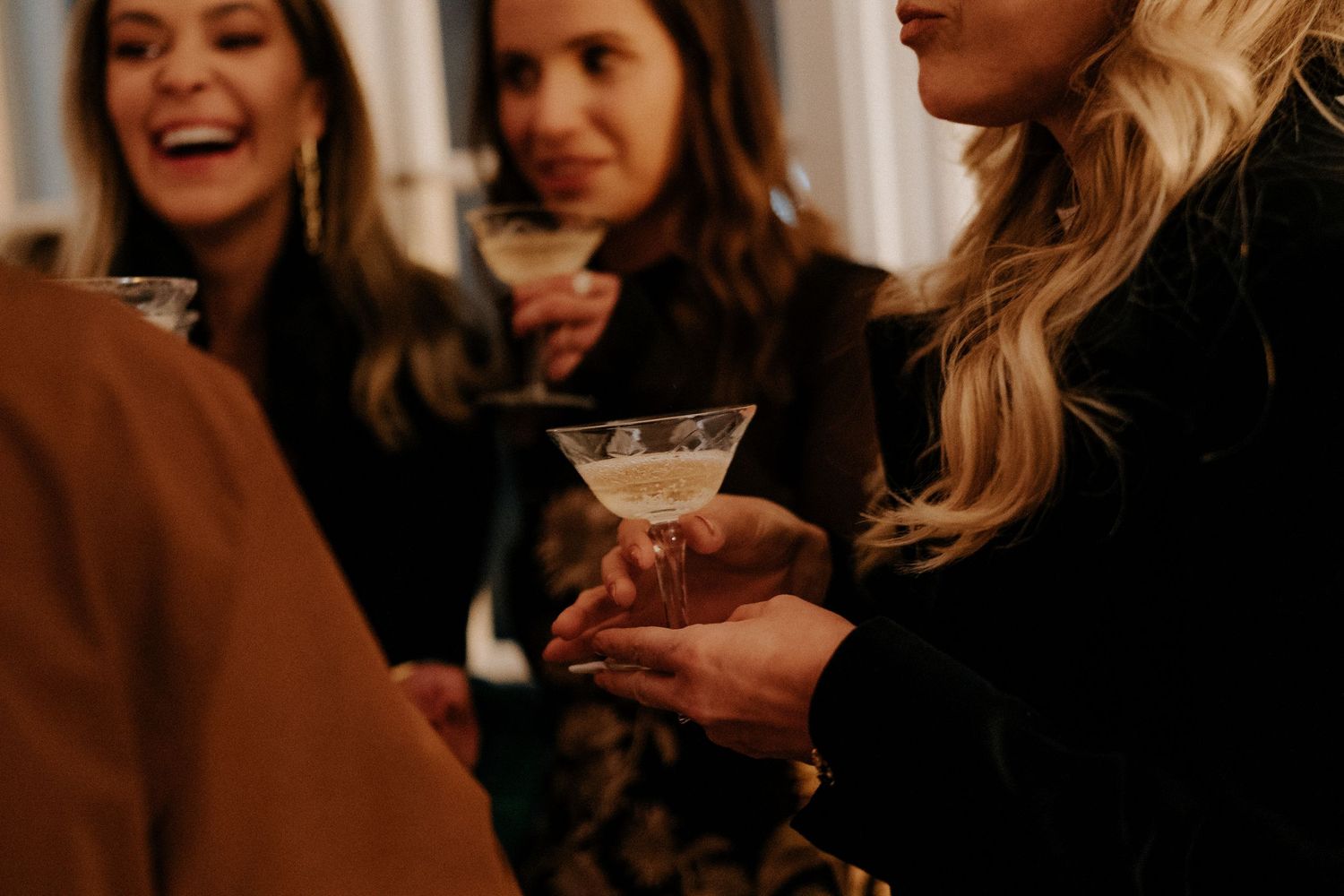 Group enjoying drinks and conversation at an indoor gathering.