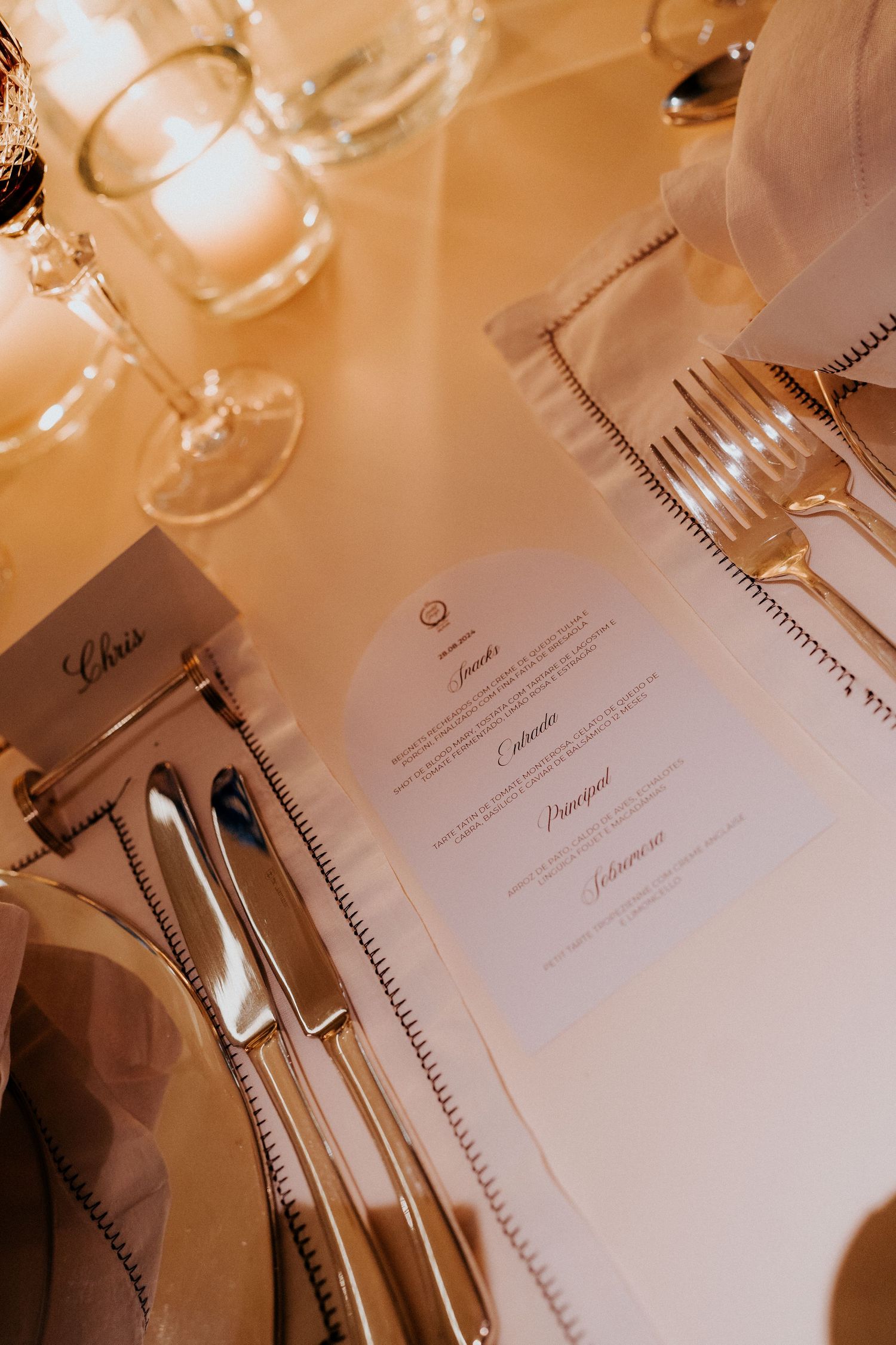 Wedding reception table setting with elegant dinnerware and menu cards.