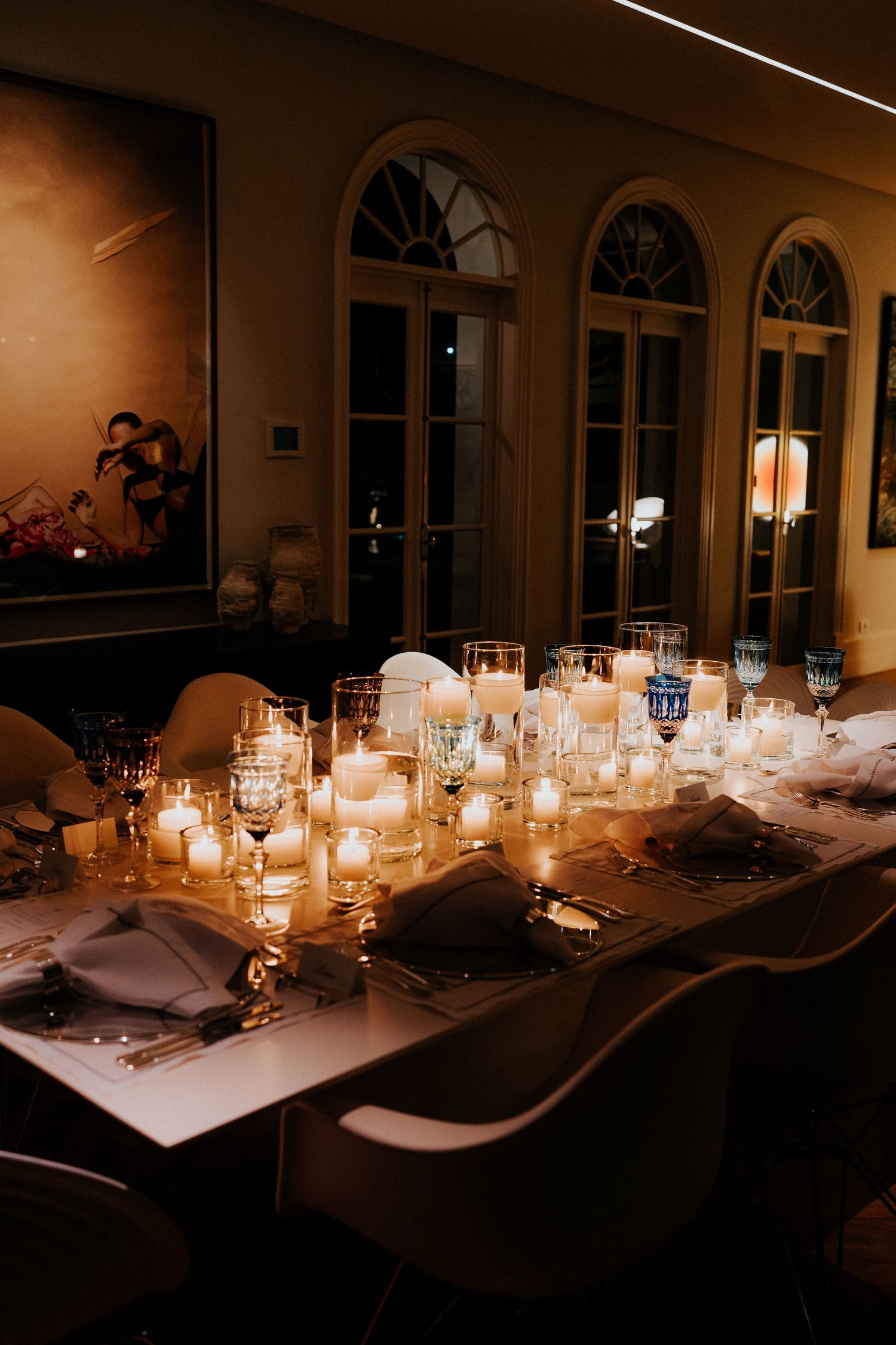 Romantic candlelit wedding reception table with glowing centerpieces and elegant place settings.