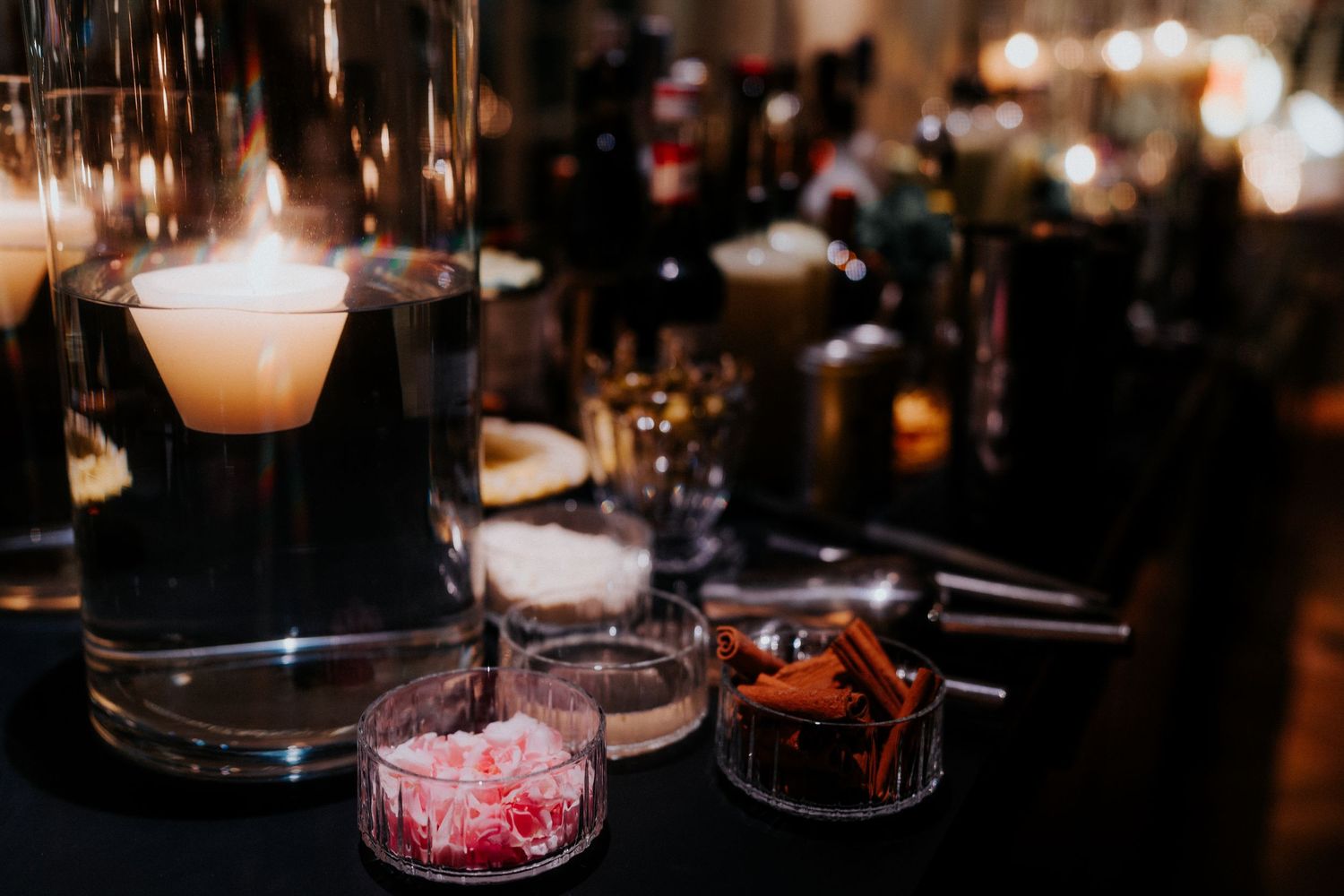 Moody reception table details with candlelight and glassware.