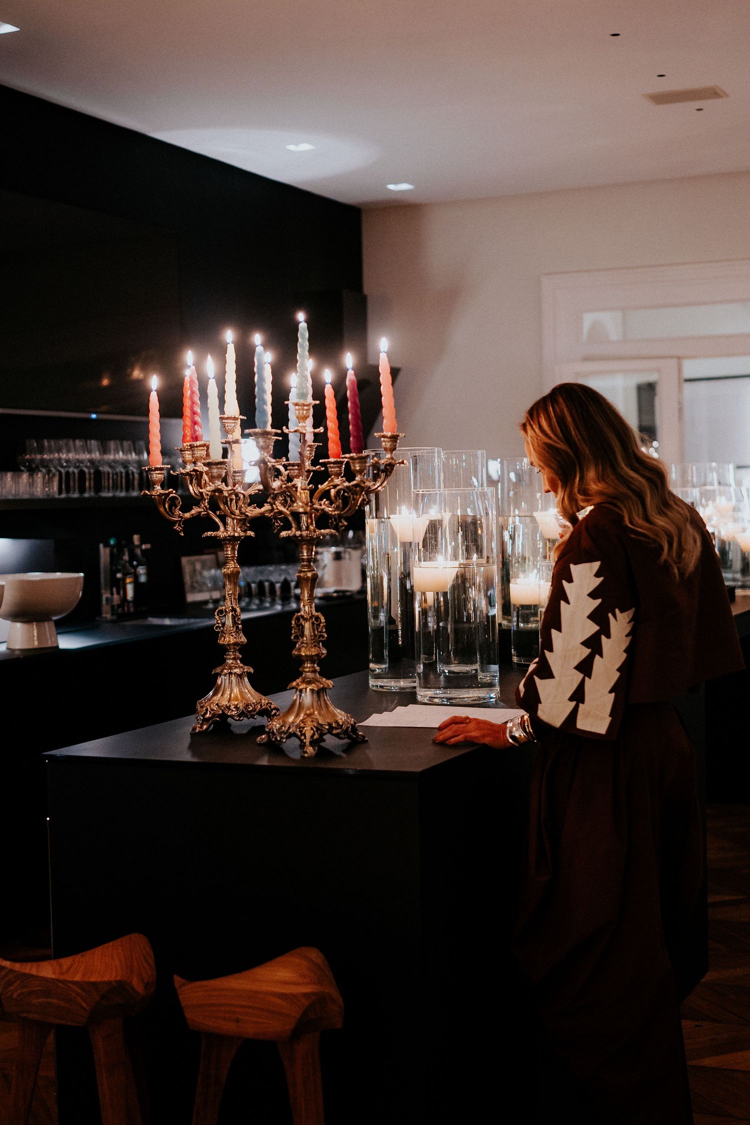 Elegant candelabras and table settings in a dimly lit reception space.