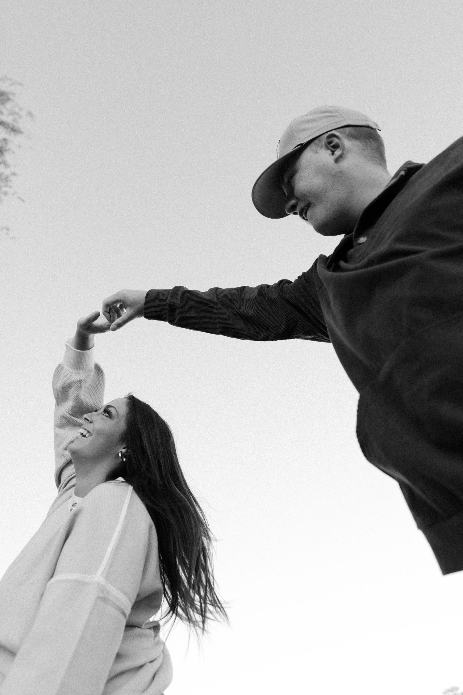Young couple spin each other around.