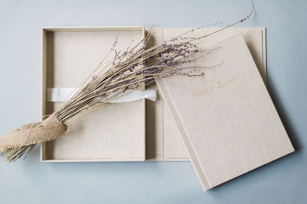 Minimalist beige paper box design with dried botanical elements on light blue background.