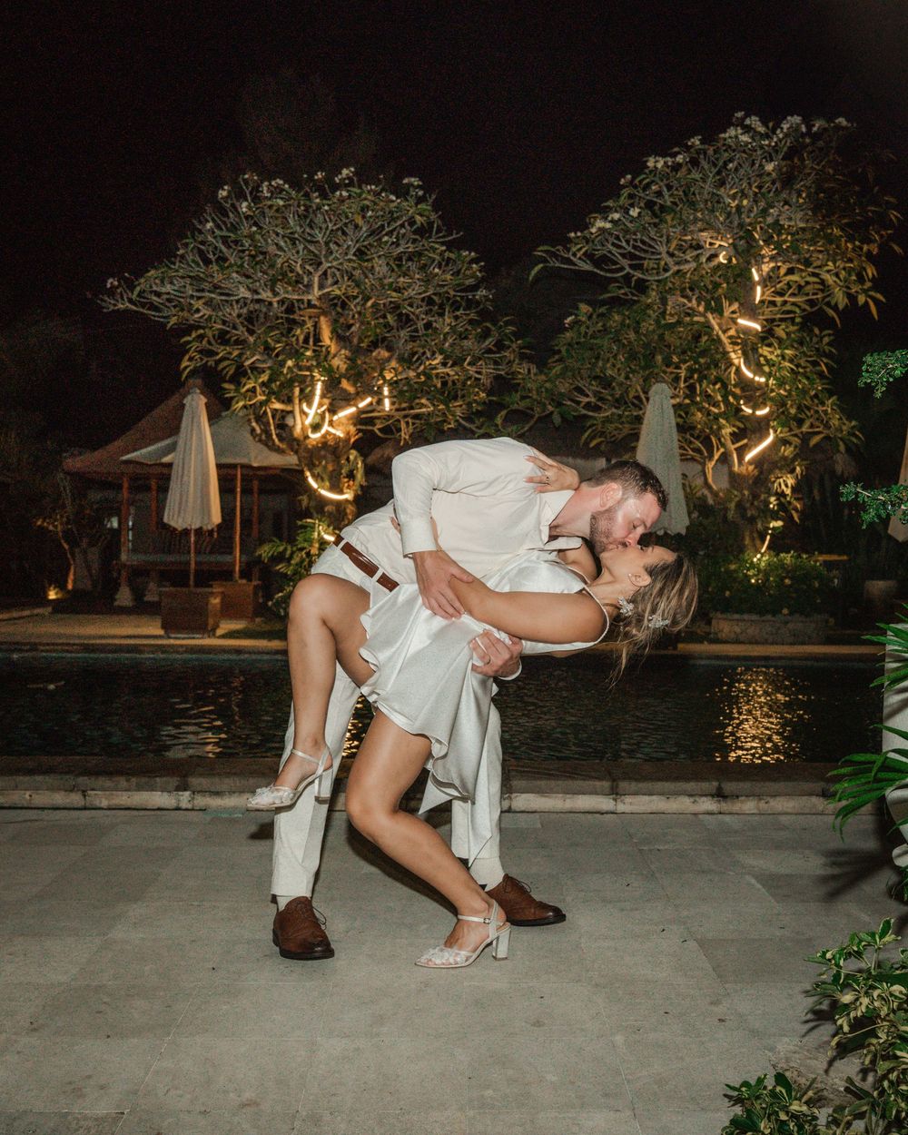 A sequence of romantic poses showing a couple dipping and dancing together at an outdoor evening wedding reception.