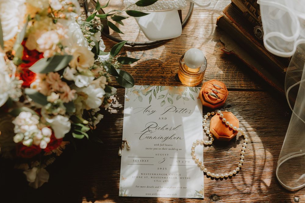Wedding reception details with floral arrangements and elegant place settings on a rustic wooden table.