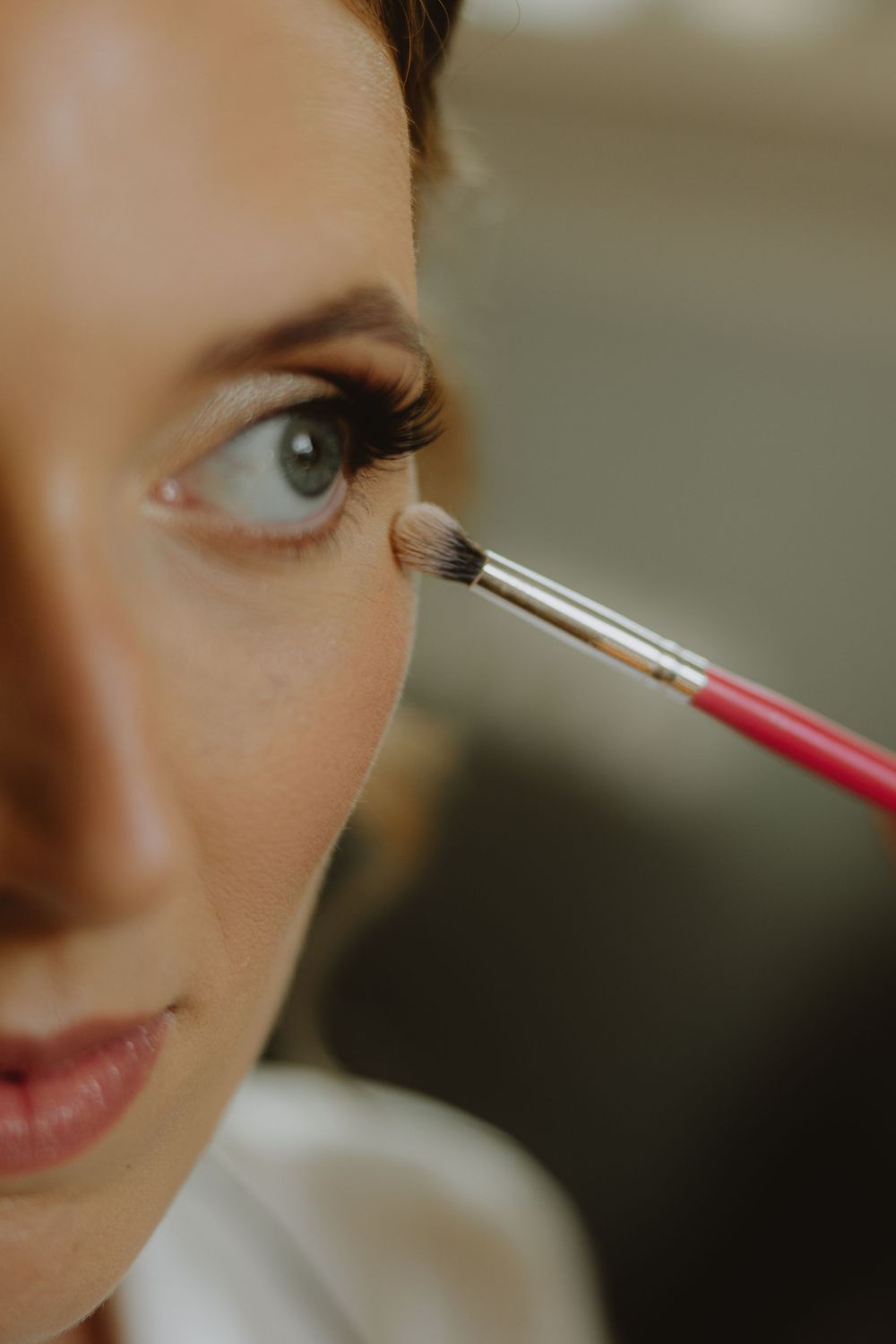 Close-up shot of eye makeup application with a small brush.