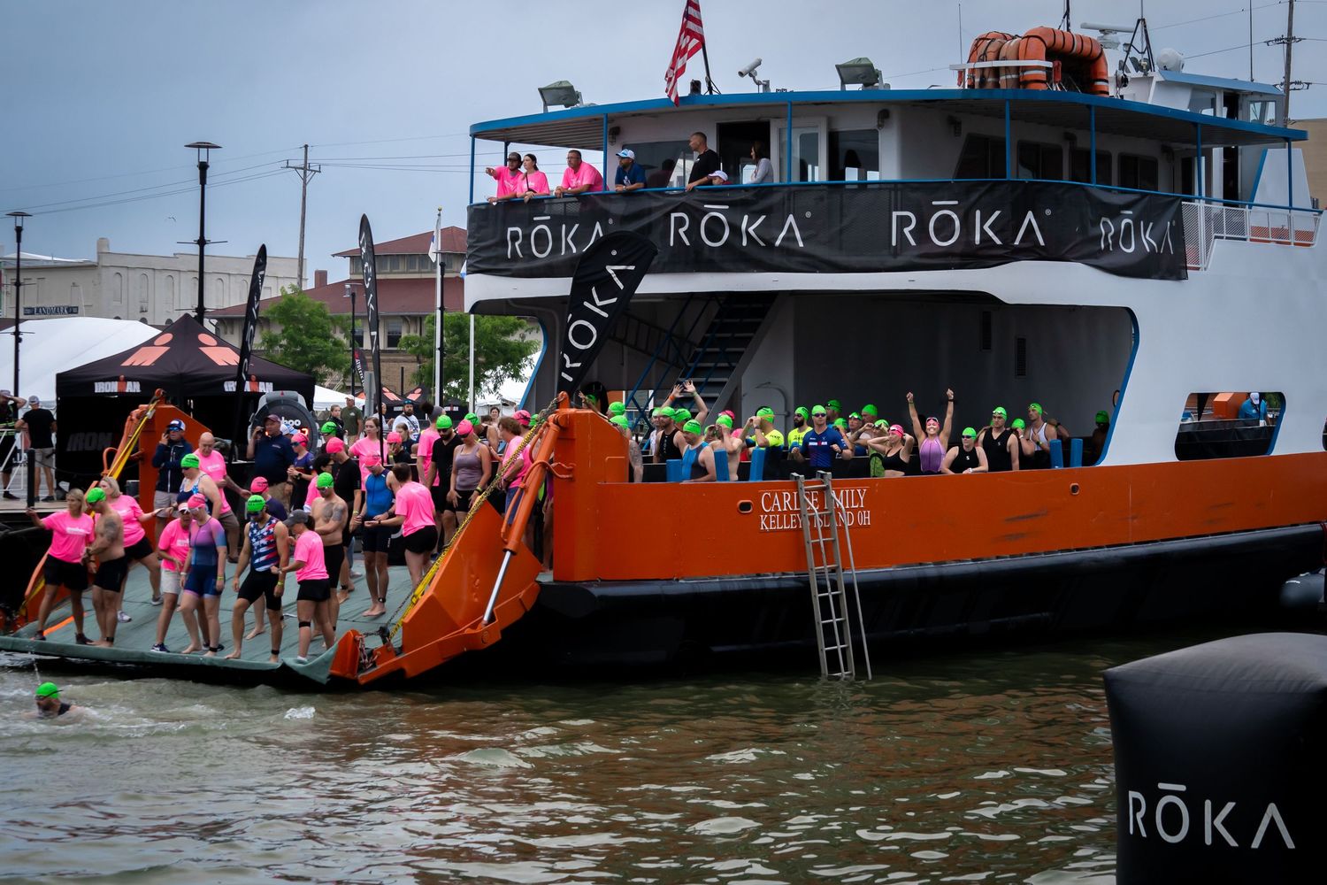 boat in Sandusky oh with people starting a race by jumping off the back to swim.