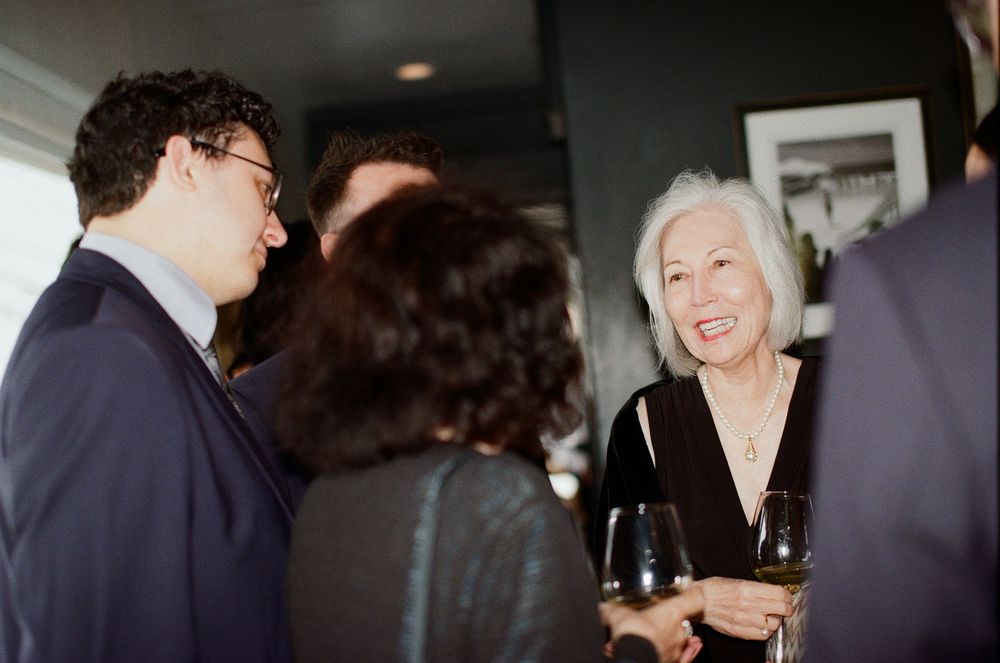Candid 35mm film photo of wedding guests laughing at a Malibu beach wedding reception.