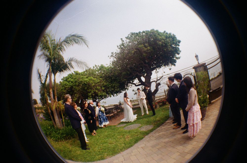 Artistic 35mm film fisheye image capturing the quiet, candid atmosphere of a Malibu beach elopement.