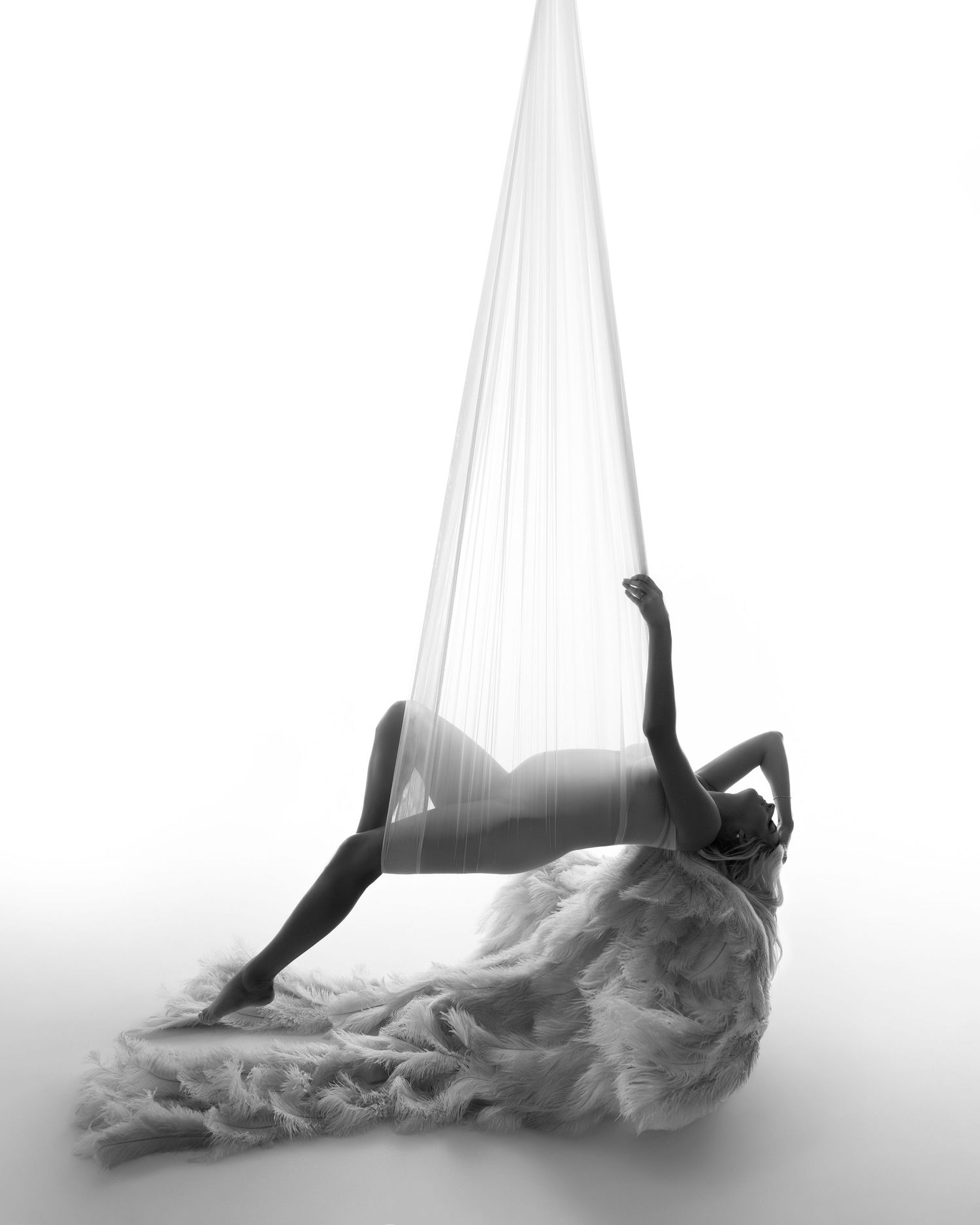 Artistic black and white photograph series showing graceful silhouettes dancing with flowing fabric in ethereal poses.
