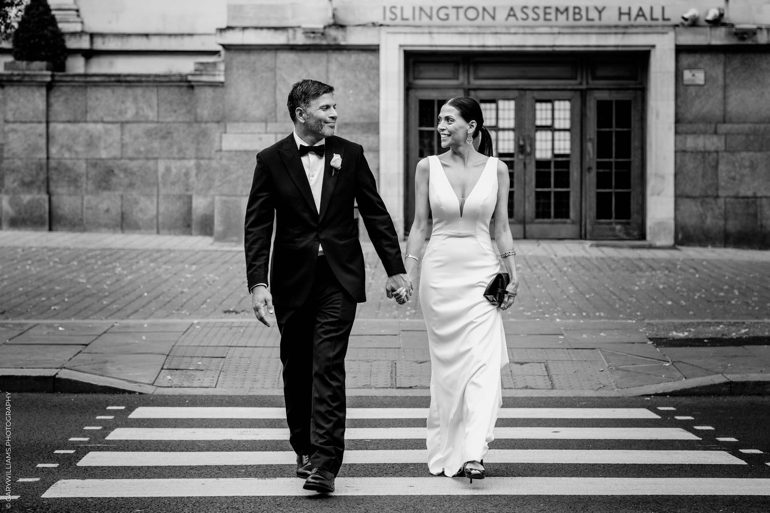 Black and white wedding photos showing couple walking together outside Islington Assembly Hall.