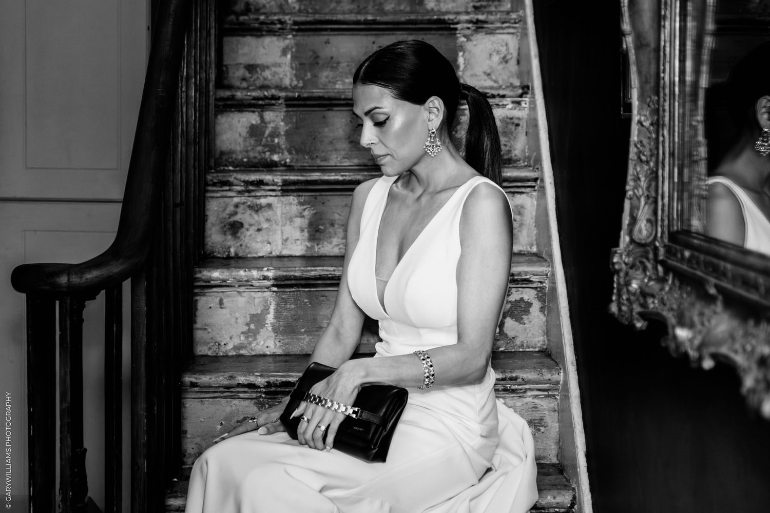 A wedding photographer moves gracefully around the dance floor while taking pictures in a black and white image.