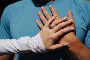Close up view of hands displaying engagement ring in natural lighting. Colchuck Lake proposal