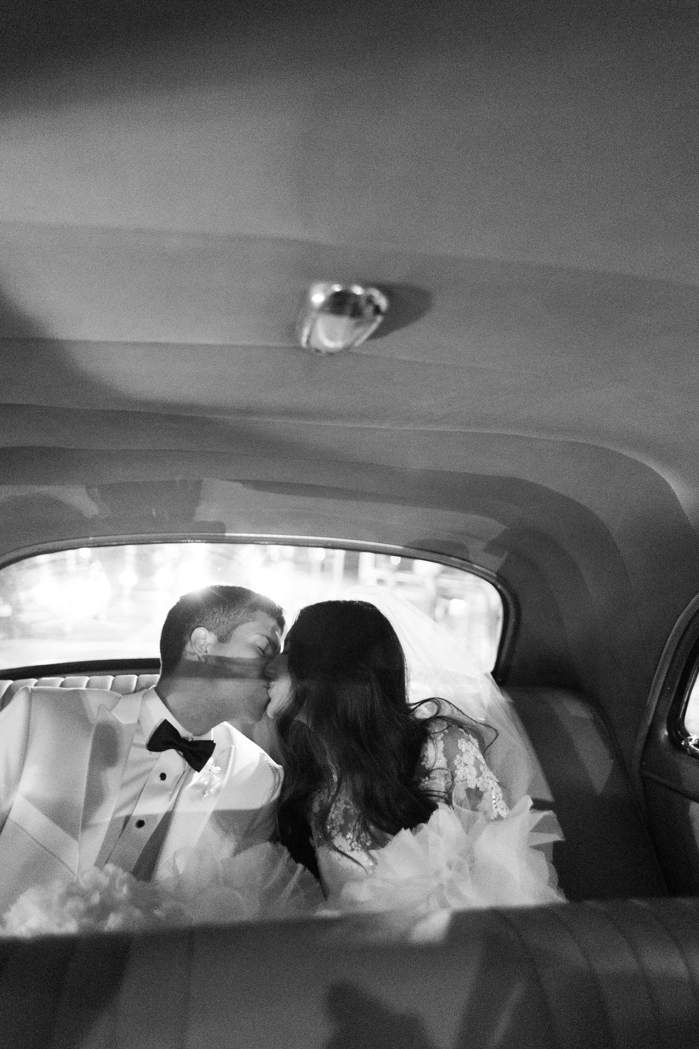 Black and white panoramic sequence showing the interior of a car with backseat passengers silhouetted against windows.