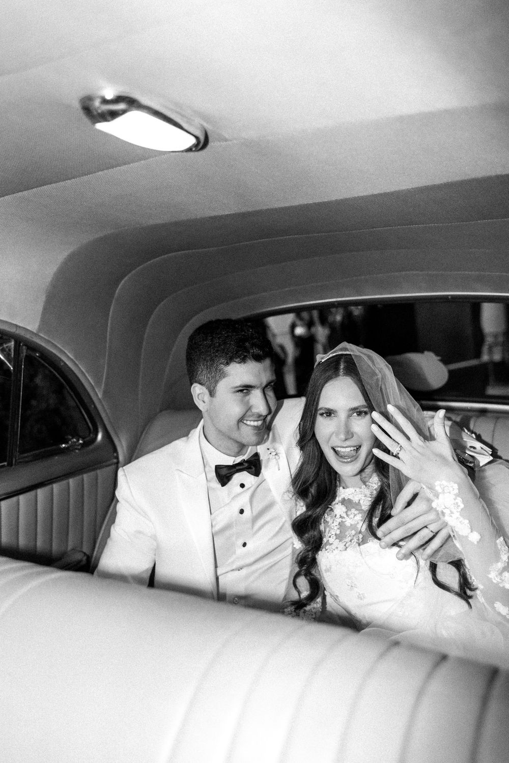 A series of candid black and white photos showing a happy couple sharing joyful moments in the backseat of a car.