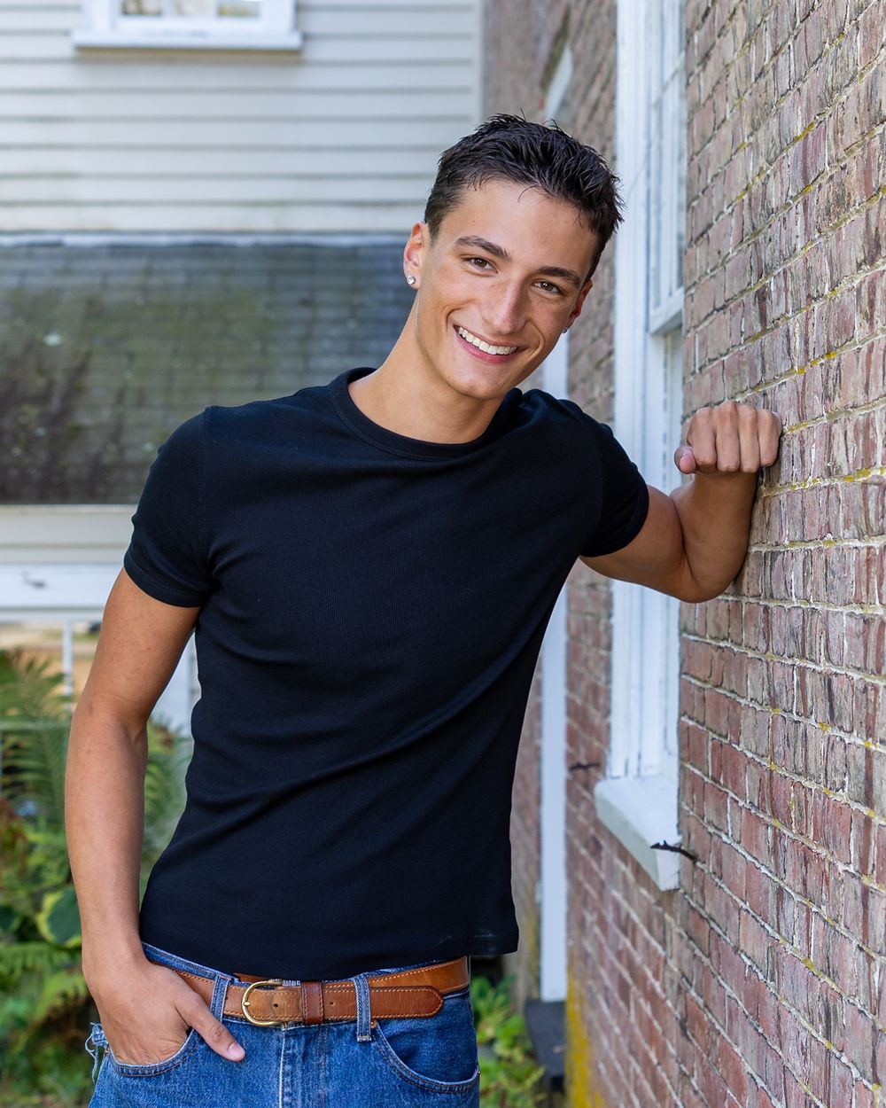 A high school senior poses for his yearbook portraits against brick wall at Heritage Park in Sudbury, MA with Lisa West Photography.