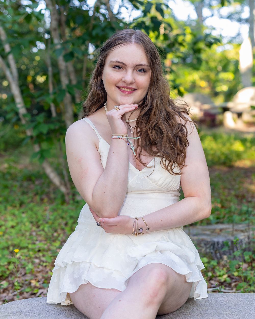 A high school senior poses for her yearbook portrait in a botanical garden in Falmouth, MA on Cape Cod with Lisa West Photography.