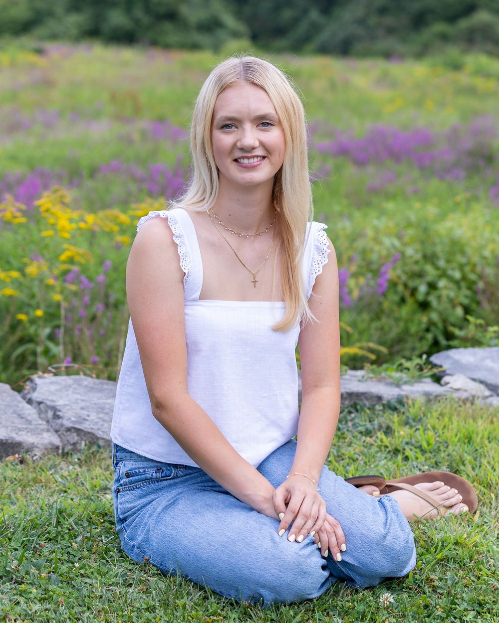 A high school senior poses for her yearbook photos in a wildflower field at the Codman Estate in Lincoln, MA with Lisa West Photography.