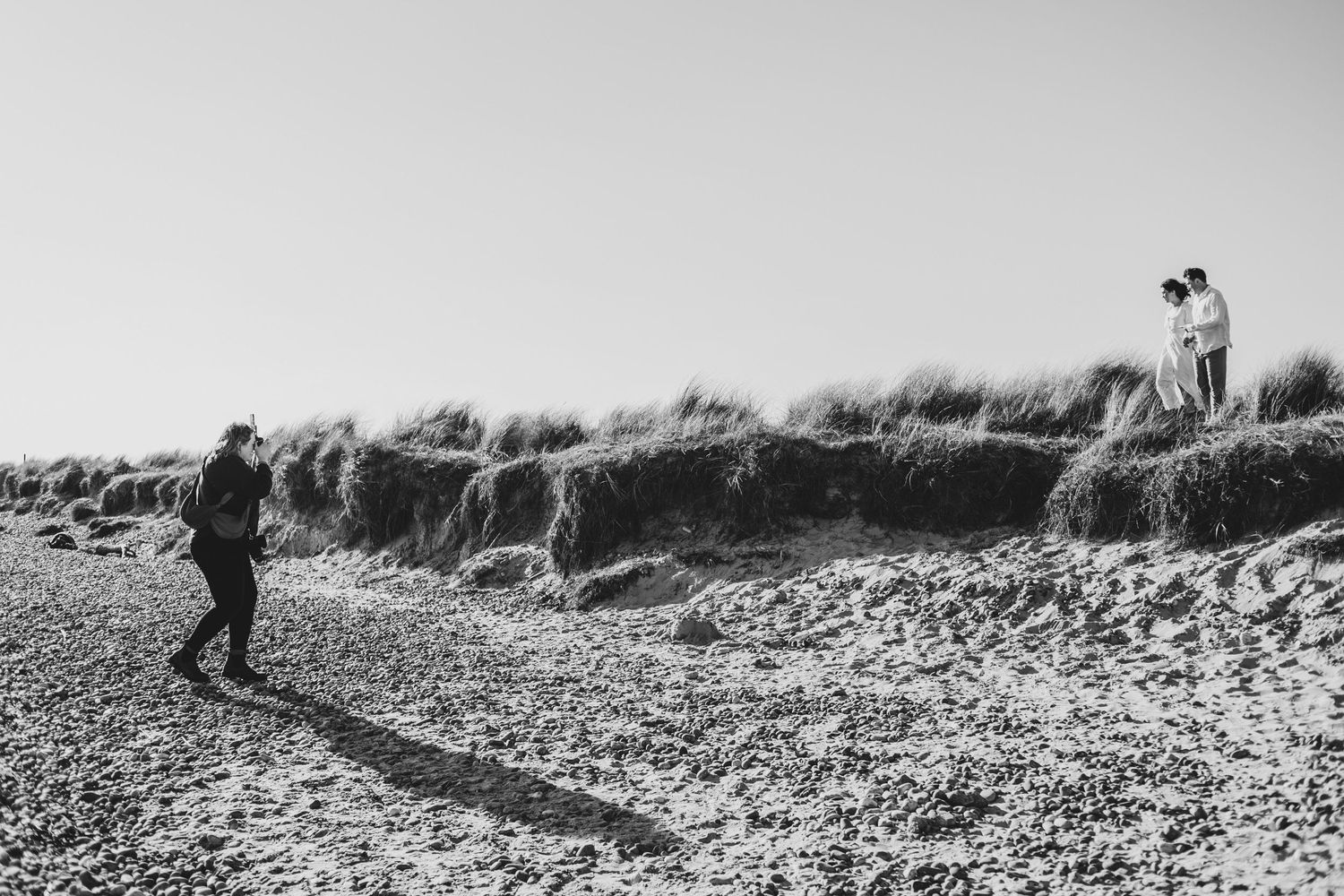 Two people exploring a rocky beach shoreline on an overcast day.
Suffolk couple photos. Beckie Egan Photography.