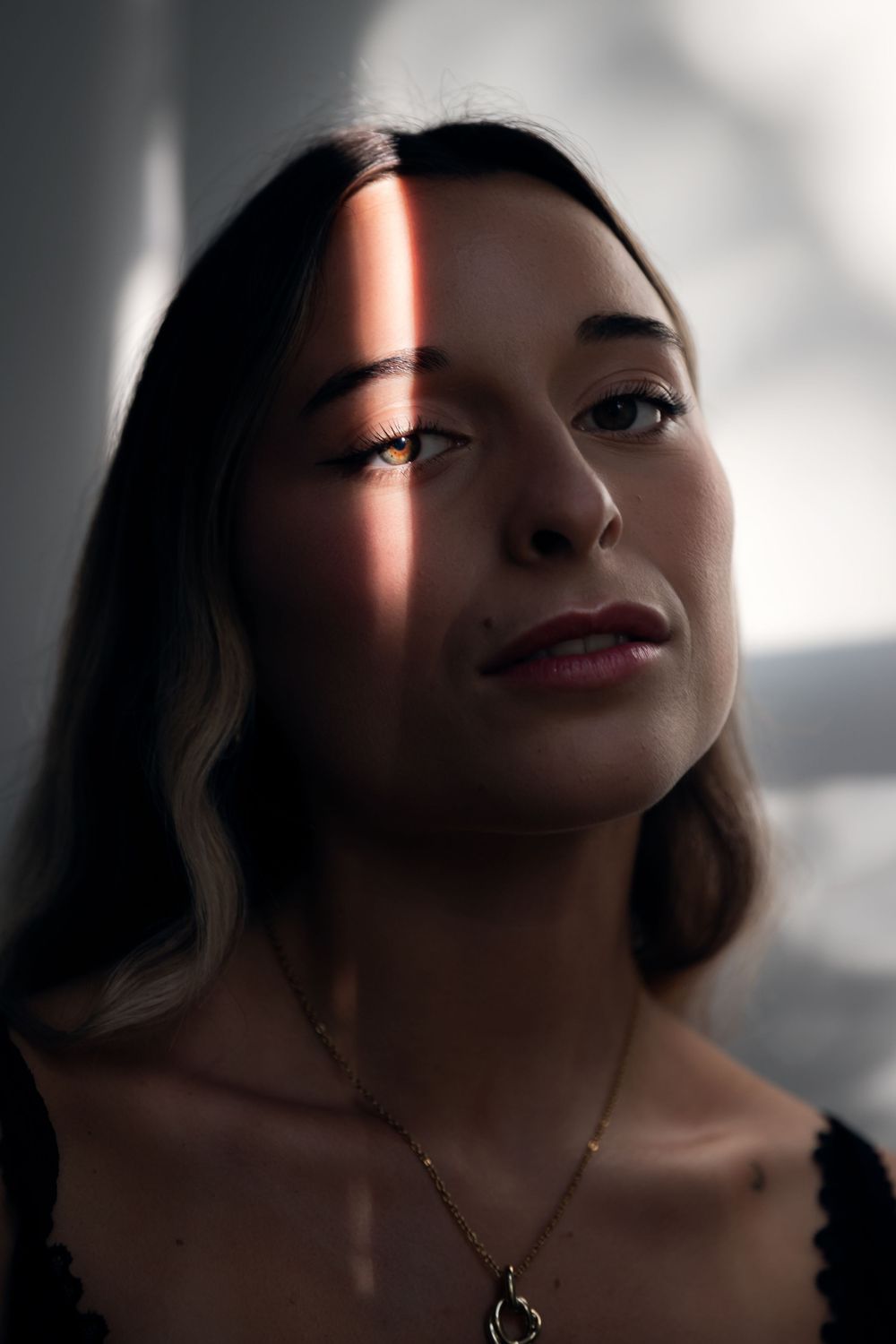 A series of dramatic portrait images with cinematic lighting highlighting shadows and red lips against a dark background.