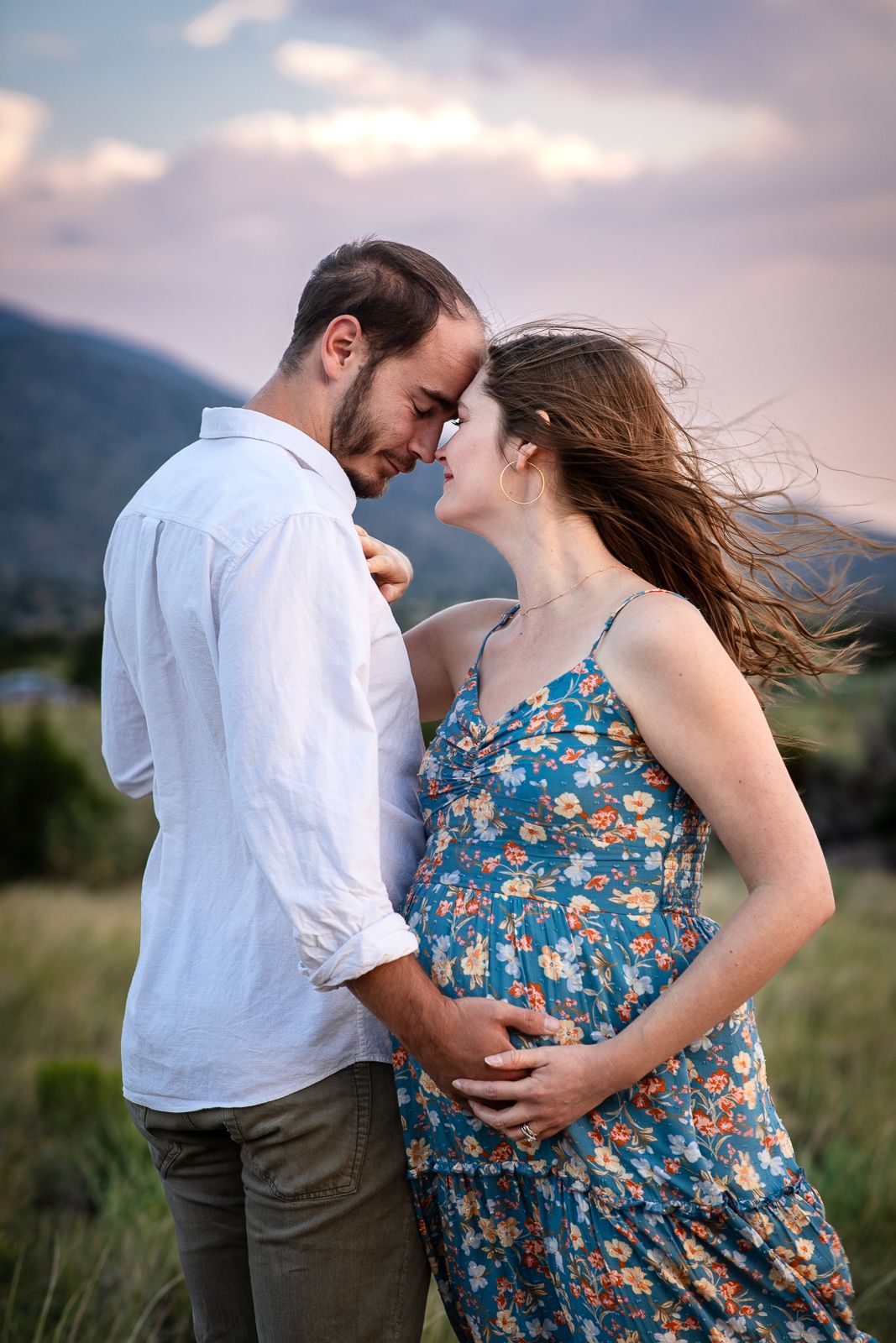Beautiful outdoor maternity photography; couple embracing in a windy New Mexico landscape; Clarissa Anello