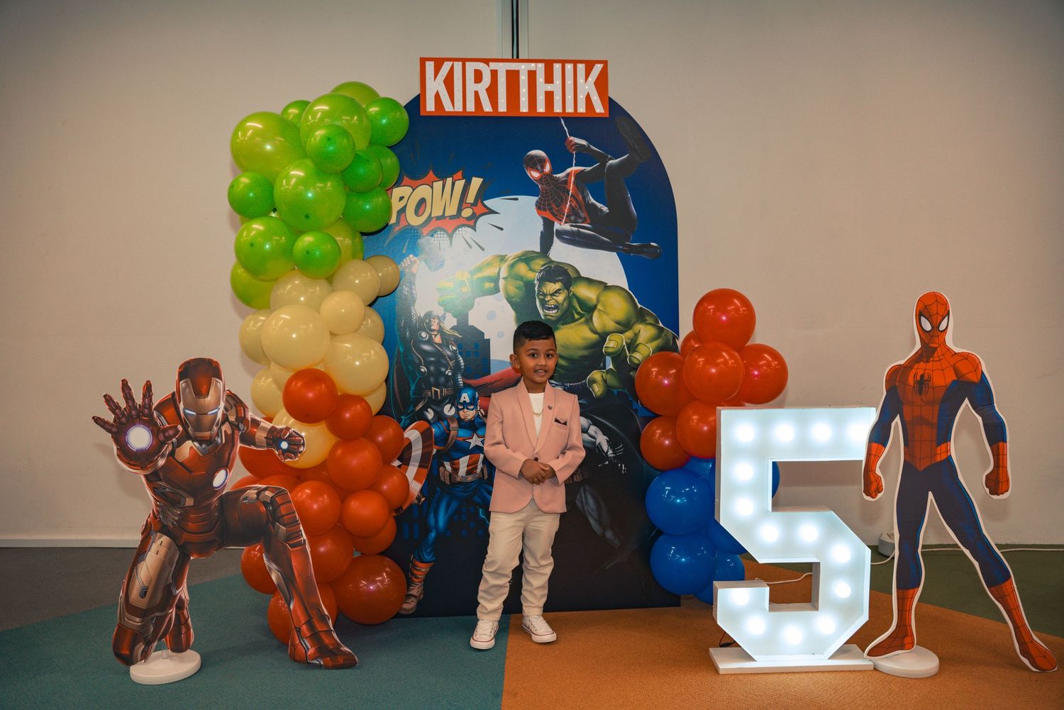 Birthday party decoration setup with superhero theme featuring Spider-Man and Iron Man standees.