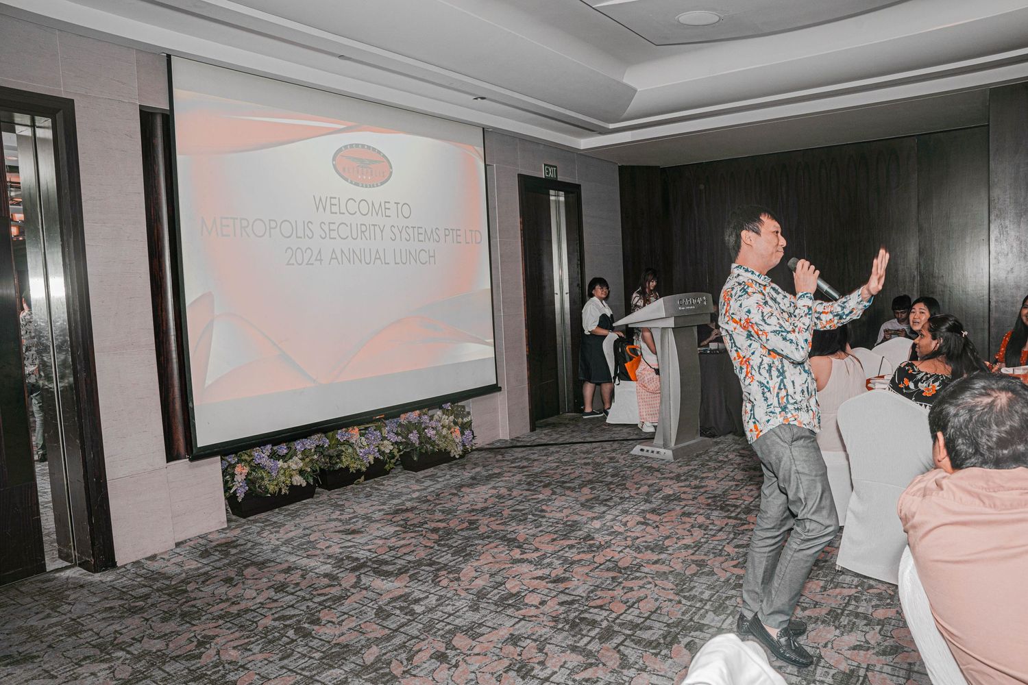 Person dancing enthusiastically in a conference room during a corporate event.