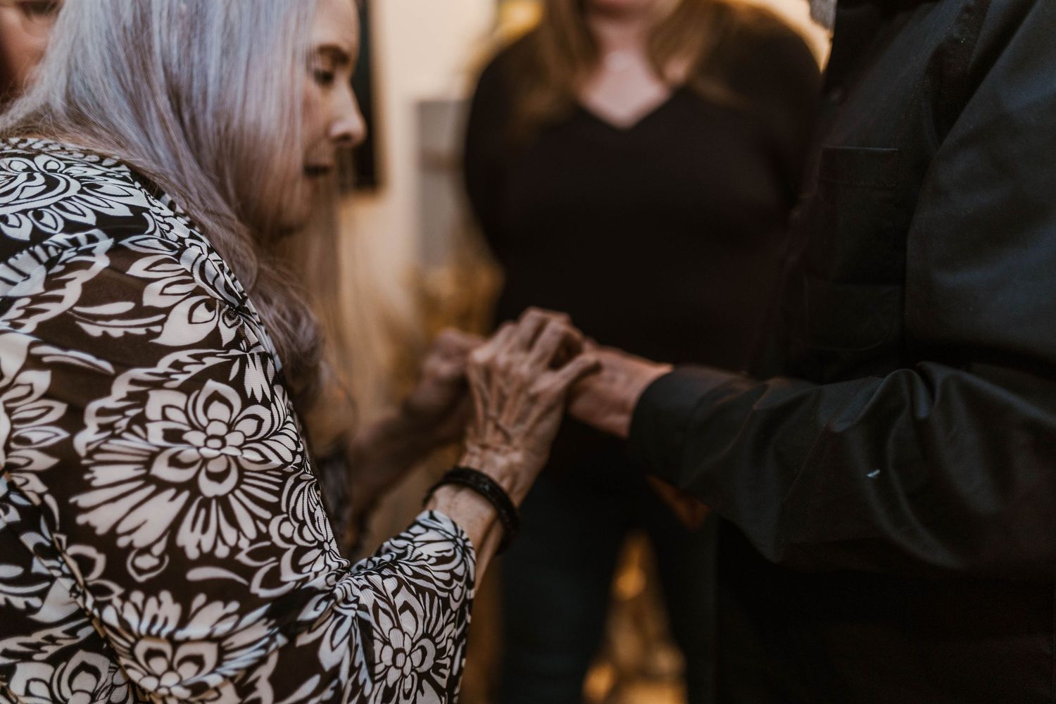 Close-up of hands during a ring exchange ceremony with floral patterned clothing visible.