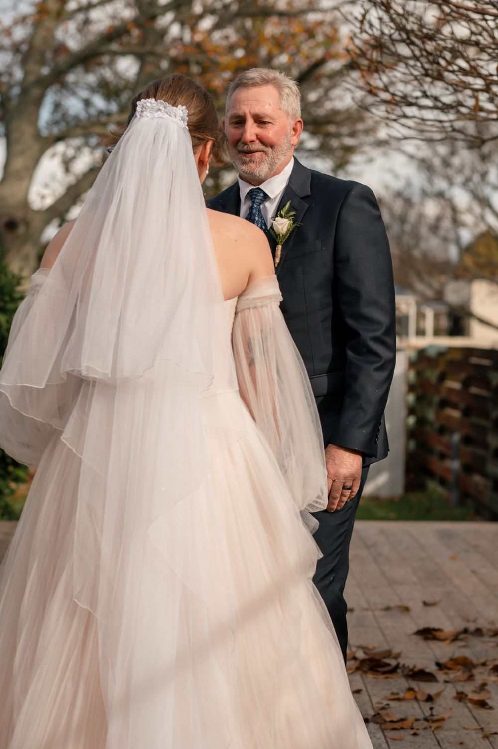 Intimate wedding moment between two people on outdoor deck during autumn Cambridge New Zealand