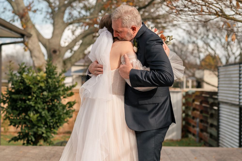 Tender embrace shared during outdoor wedding ceremony on wooden deck Cambridge New Zealand