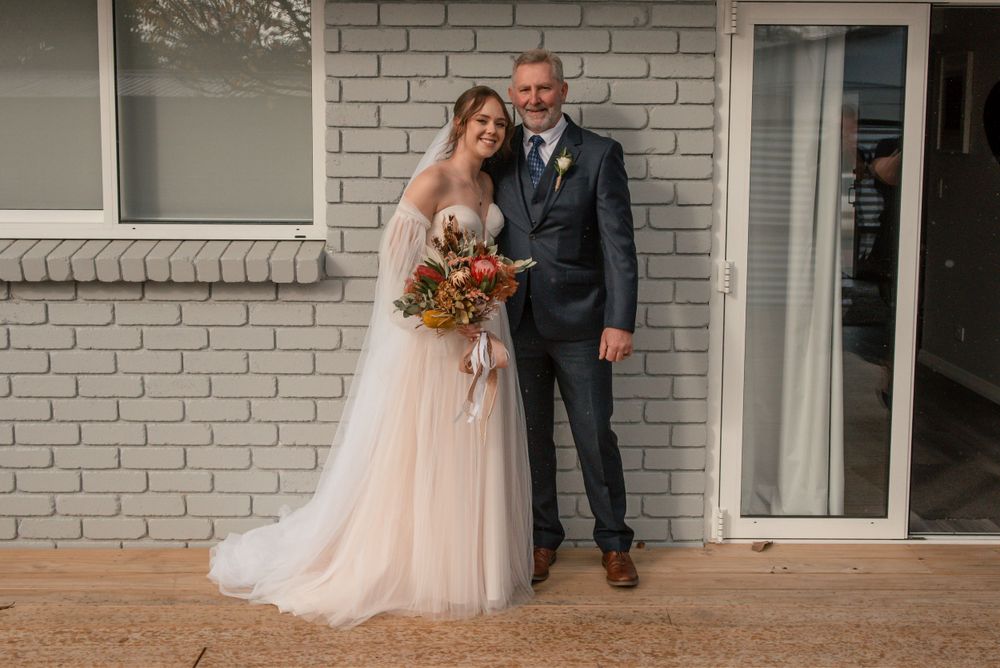 Wedding portrait against white brick wall with autumn bouquet and classic styling Cambridge New Zealand