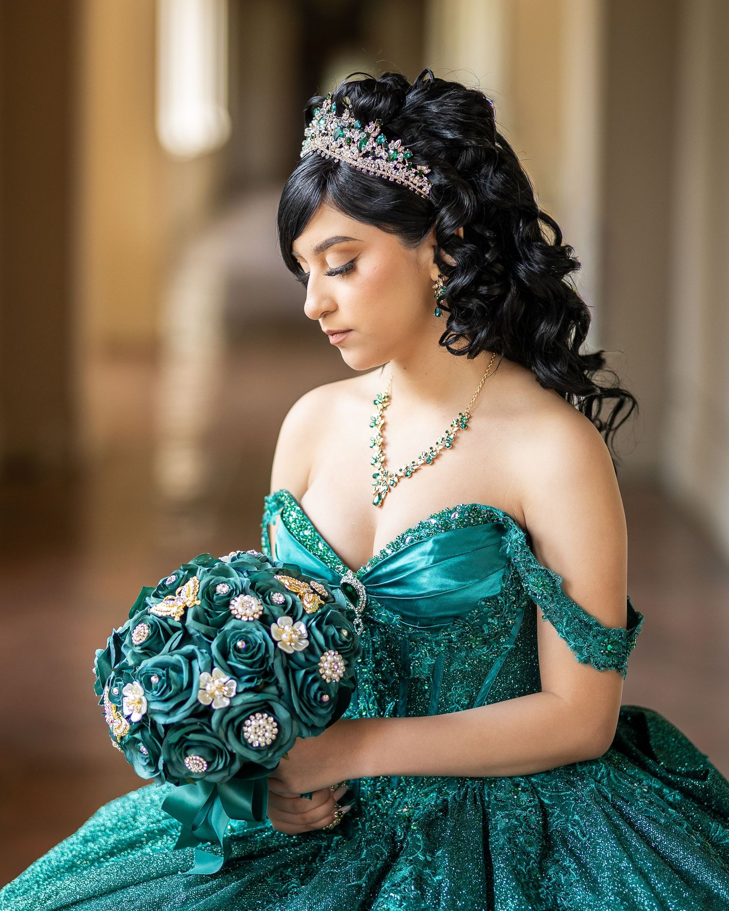 Quinceañera poses in a lovely green dress using natural light. The photographer poses model to ensure a nice moody feel to photo.