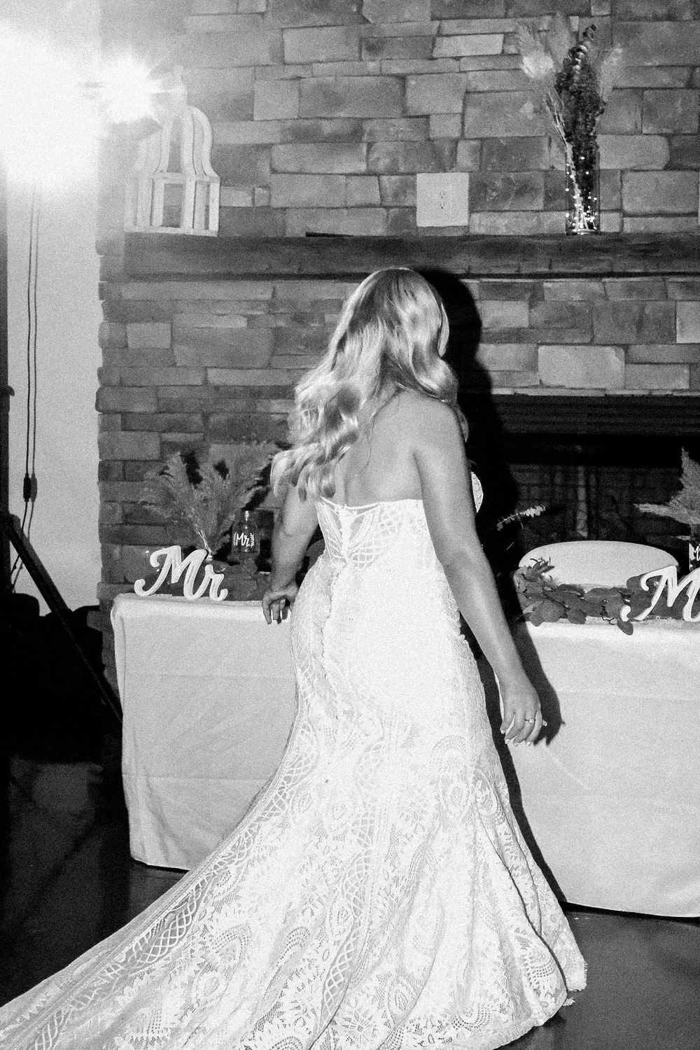 A white lace dress twirls gracefully in a series of dance movements at an indoor venue.
