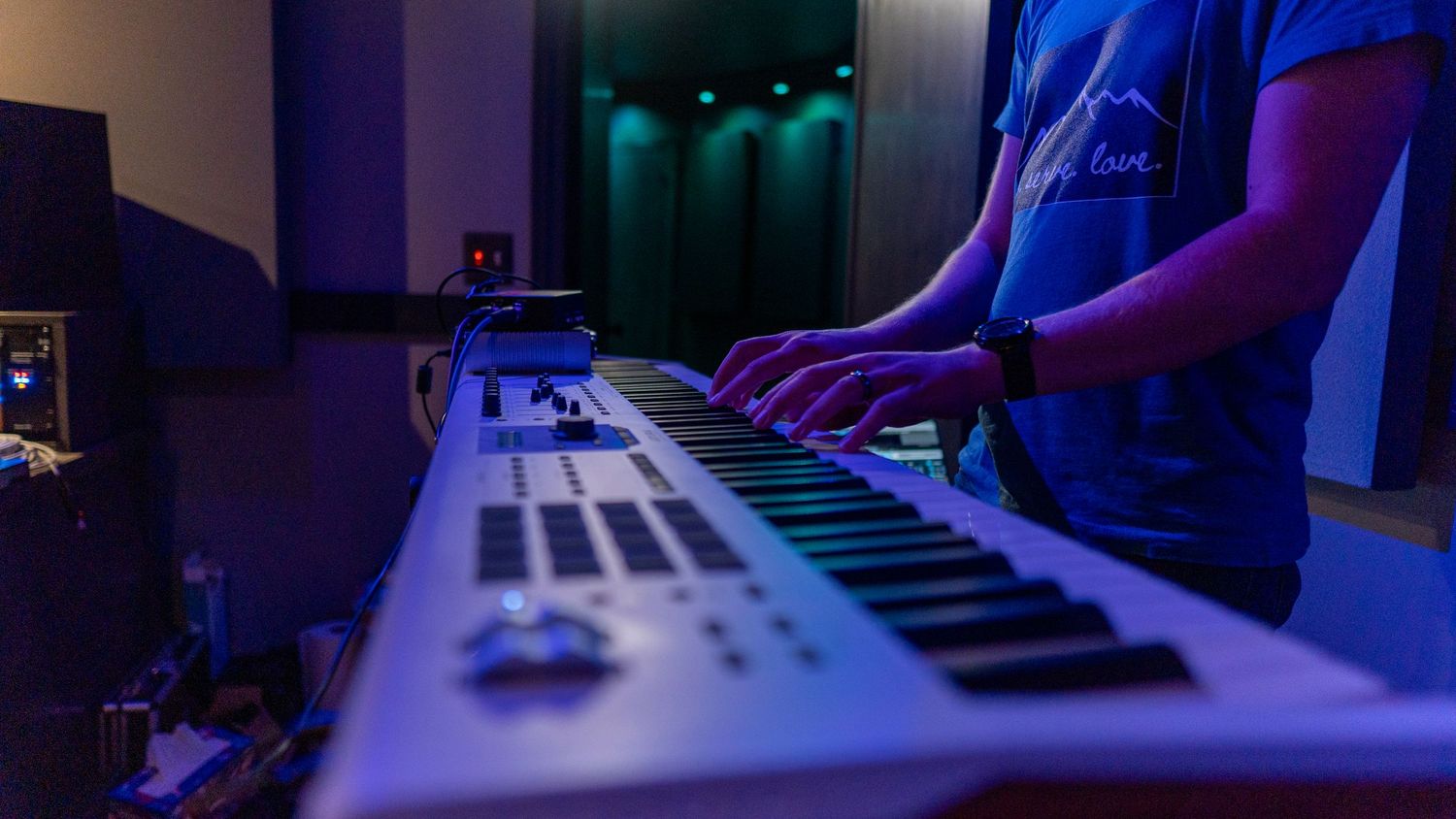 A keyboard with someone playing it
