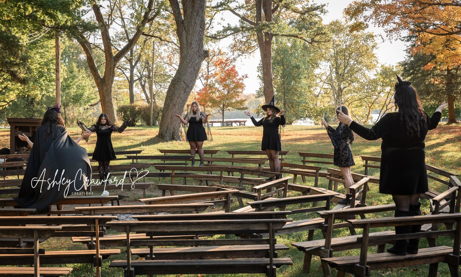 Silhouettes of people standing on wooden benches in a park during autumn.