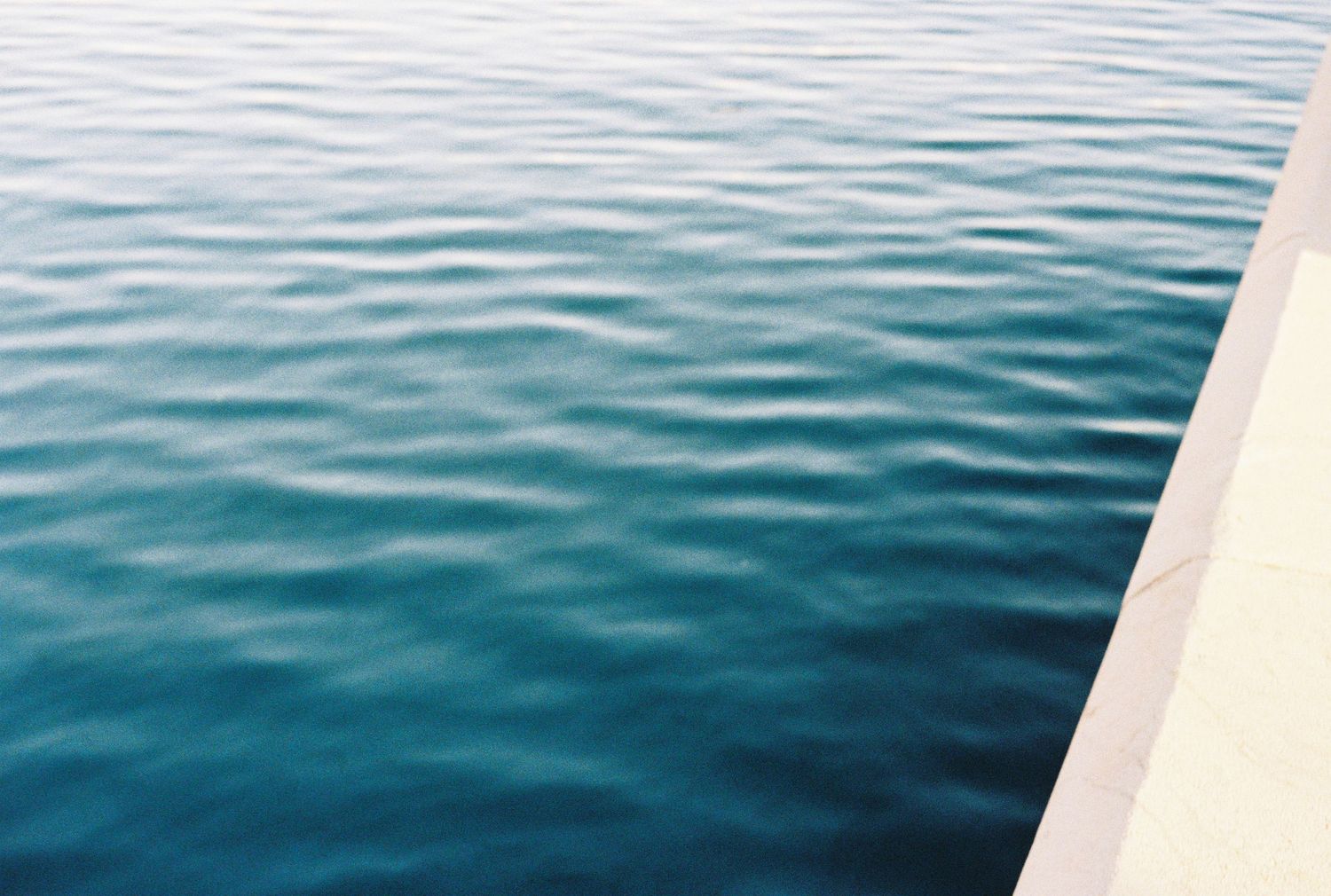 Rippling blue water surface photographed from boat edge.