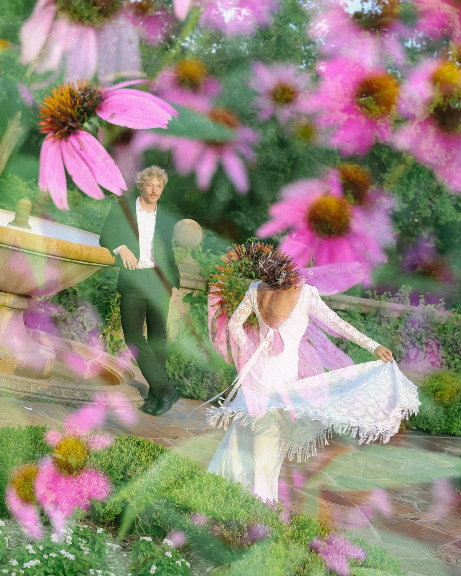Dreamy floral scene with pink coneflowers surrounding figures in an ethereal garden setting.
