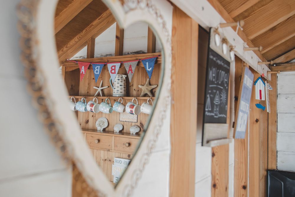 Heart-framed view of rustic wooden wall decor with festive bunting and chalkboard in a cozy cottage setting.