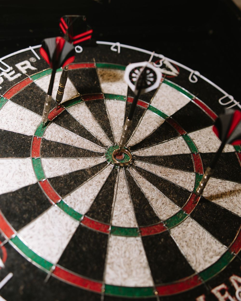 Close-up of a dartboard with darts stuck in the bullseye area.