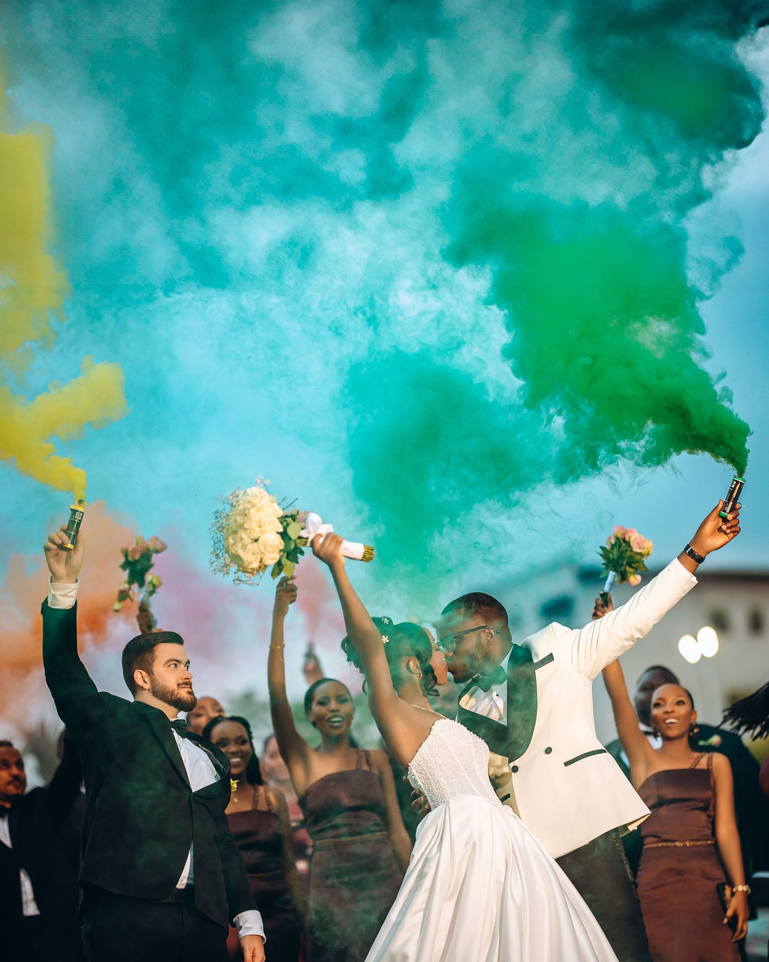 Celebrating crowd at an event engulfed in vibrant green smoke effects creating an energetic party atmosphere.